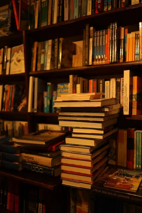 Books arranged on a table beside a bookshelf