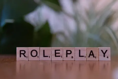 Wooden letters spelling PLAY on a beige surface