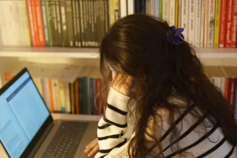 A woman studying with a laptop in a library