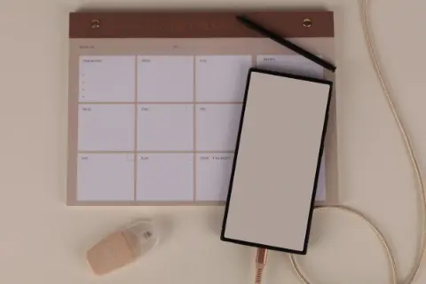 A modern desk setup with a weekly planner and stationery