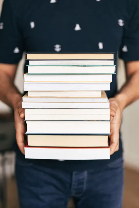 A person carrying a stack of books