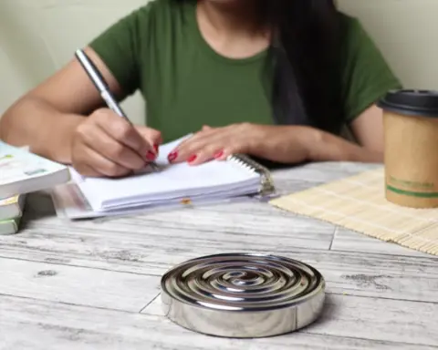 A woman writing in a notebook at a desk
